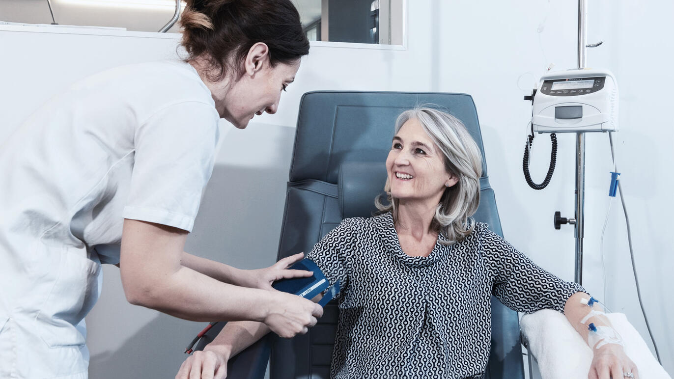 Pflegefachperson misst Blutdruck einer Patientin