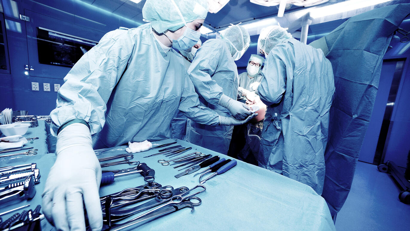 Operationstechnikerin reicht das passende Operationsbesteck.