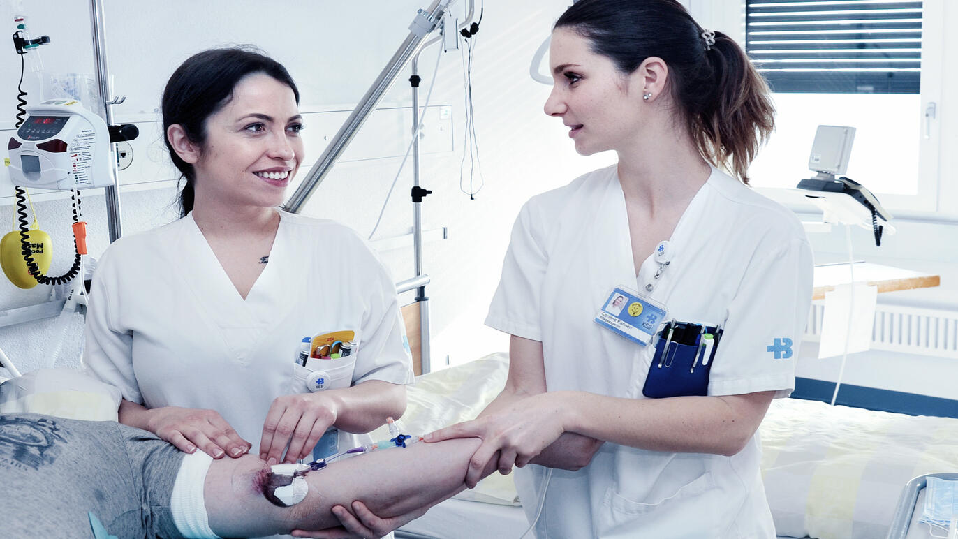 Zwei Pflegefachpersonen betreuen einen Patienten