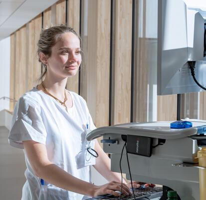 Pflegefachperson schreibt Bericht im Gang
