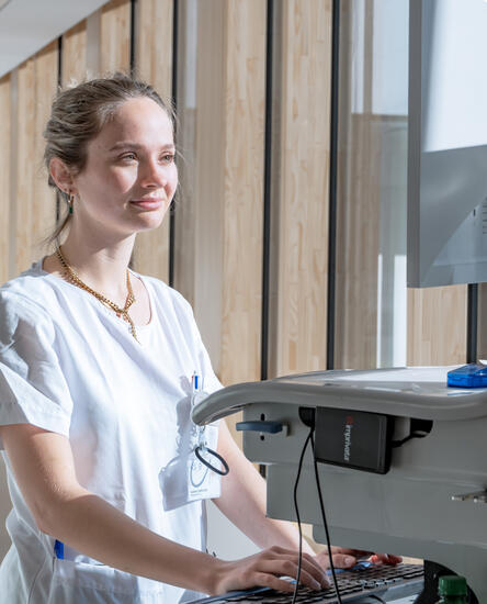 Pflegefachperson schreibt Bericht im Gang