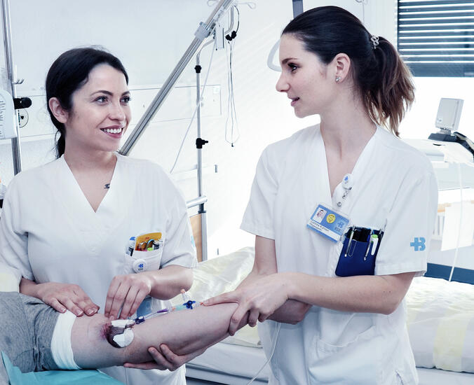Zwei Pflegefachpersonen betreuen einen Patienten