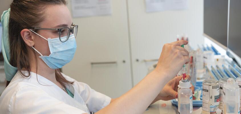 Pflegefachfrau Patricia Rheiner bereitet eine Infusion vor.