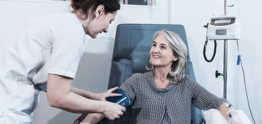 Pflegefachperson misst Blutdruck einer Patientin
