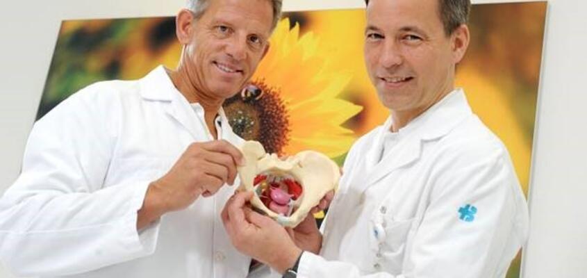 Dr. Rüdiger Mascus und Prof. Martin Heubner (links) mit einem Modell des Beckenbodens.